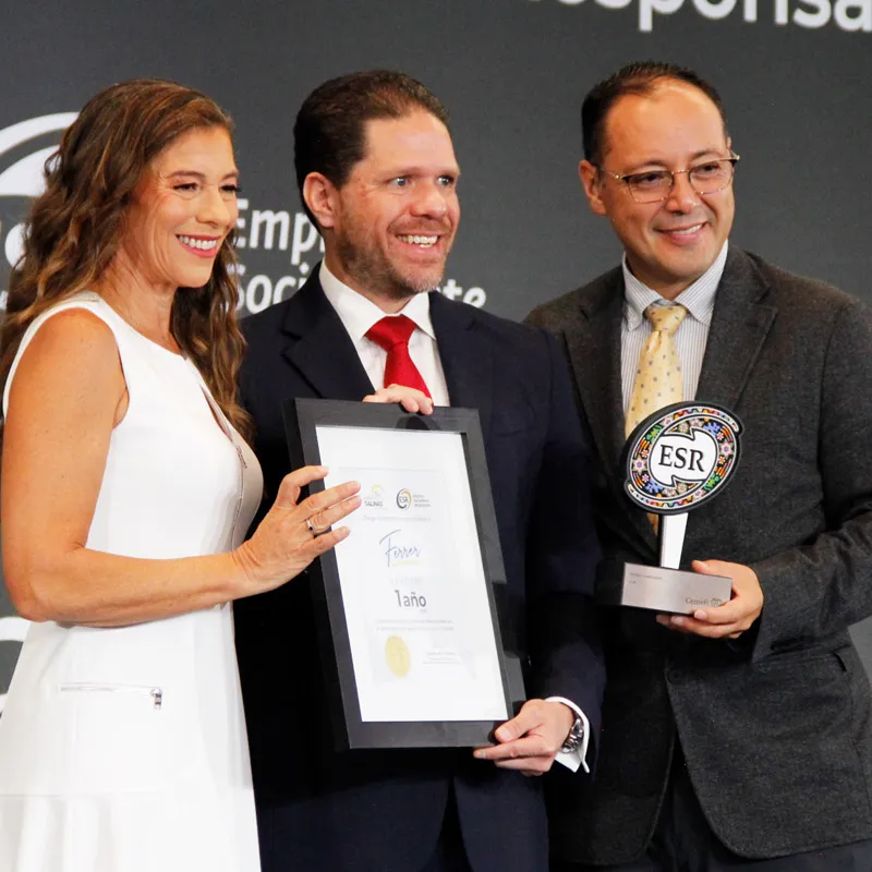 Equipo directivo de Ferrer & Asociados posando con el reconocimiento y el trofeo del Distintivo ESR durante la ceremonia de premiación
