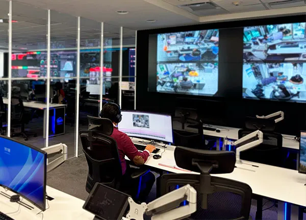 Analista del NOC con headset monitoreando pantallas de videovigilancia en tiempo real