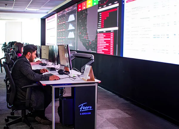 Analista del NOC trabajando frente a dashboards con un mapa de México en la pantalla de fondo